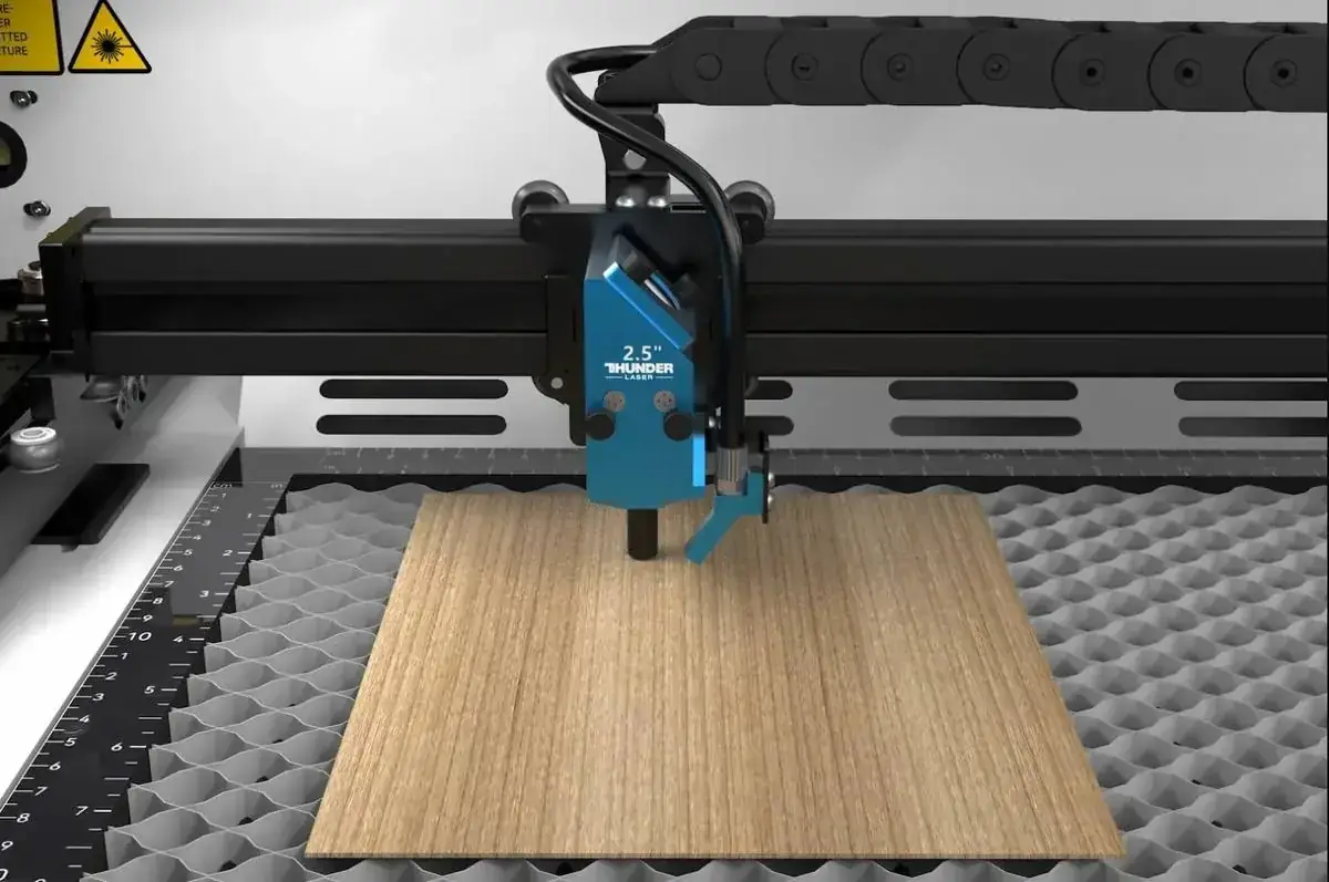 CO₂ laser head cutting a sheet of wood